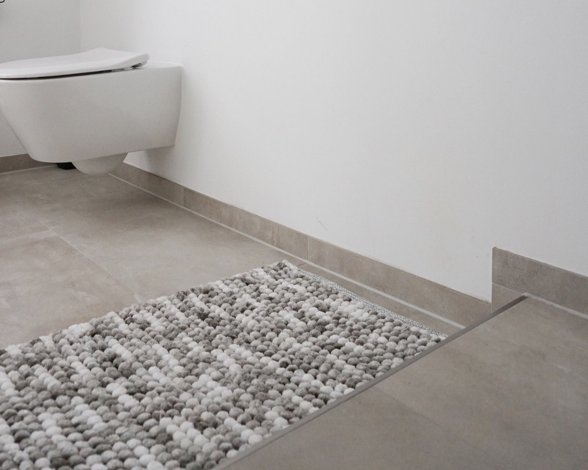 Der dekorative Badteppich hat eine schwere Qualität aus Polyester und Baumwolle.