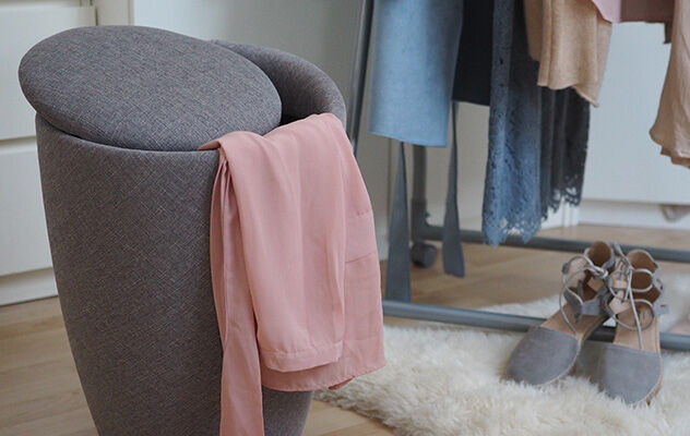 Ein Badhocker gefüllt mit Wäsche in einem Wohnzimmer