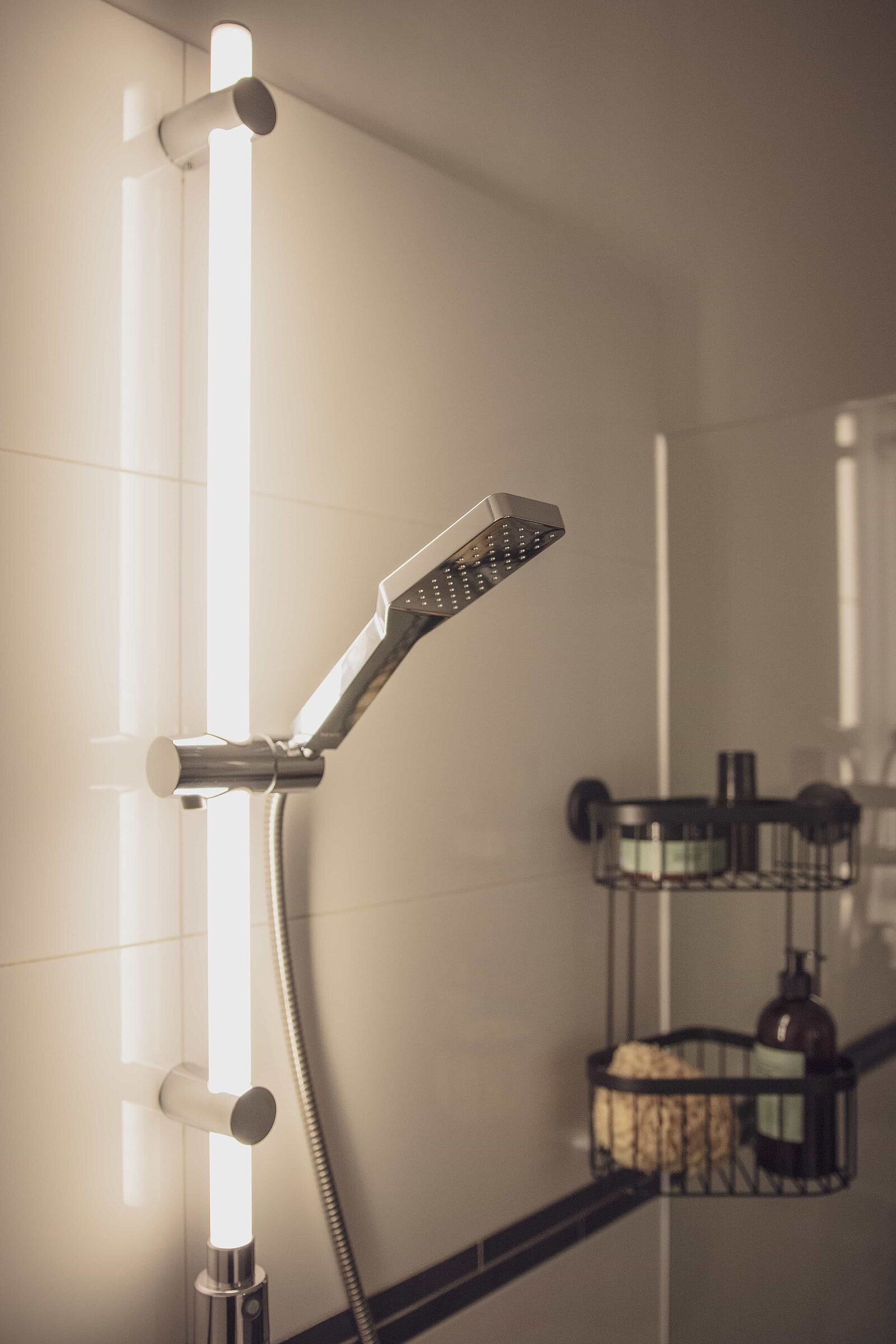 EIn weißes Badezimmer mit dem Fokus auf die LED Duschstange von WENKO