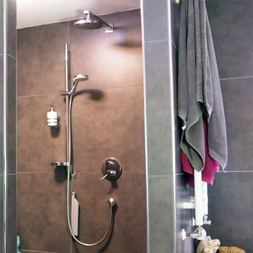 Chrom-Halterung in einer modernen Dusche mit Duschutensilien.
